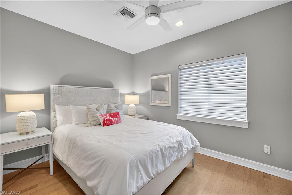 Bedroom with light wood-style floors, ceiling fan, and recessed lighting