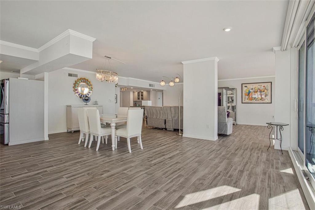 Dining space featuring wood finish floors, a chandelier, and ornamental molding