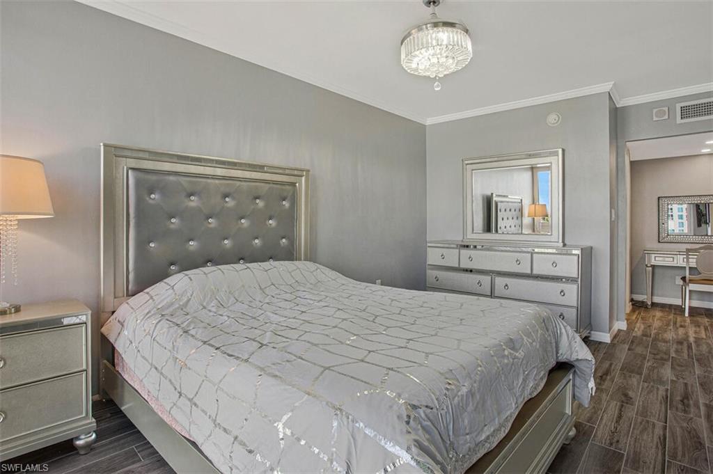 Bedroom featuring wood finish floors and crown molding