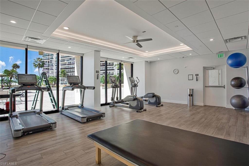 Exercise room featuring expansive windows, ceiling fan, and recessed lighting