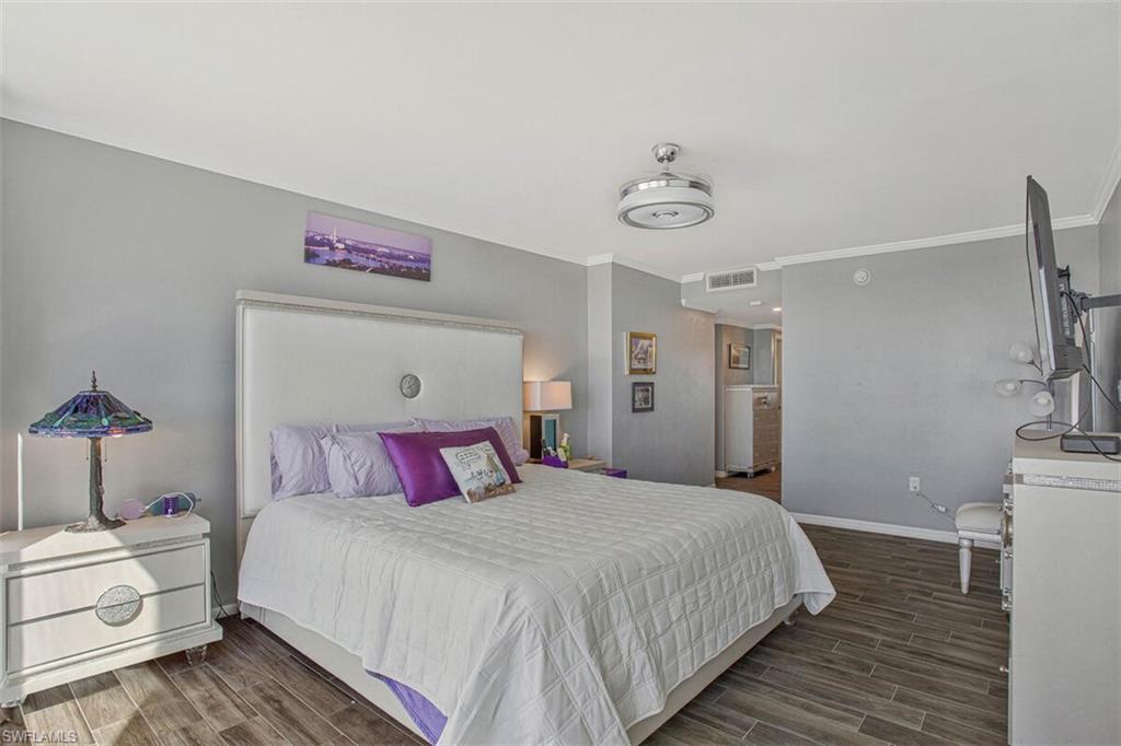 Bedroom with wood finish floors and crown molding