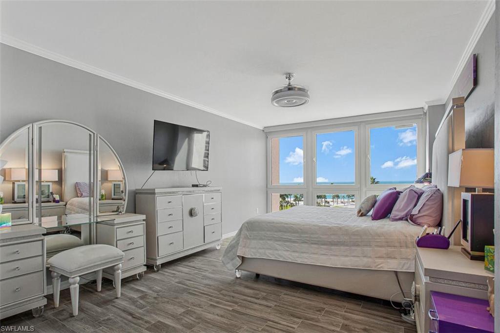 Bedroom with crown molding and wood finished floors
