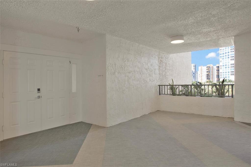 Carpeted spare room with a textured ceiling, a textured wall, and a city view
