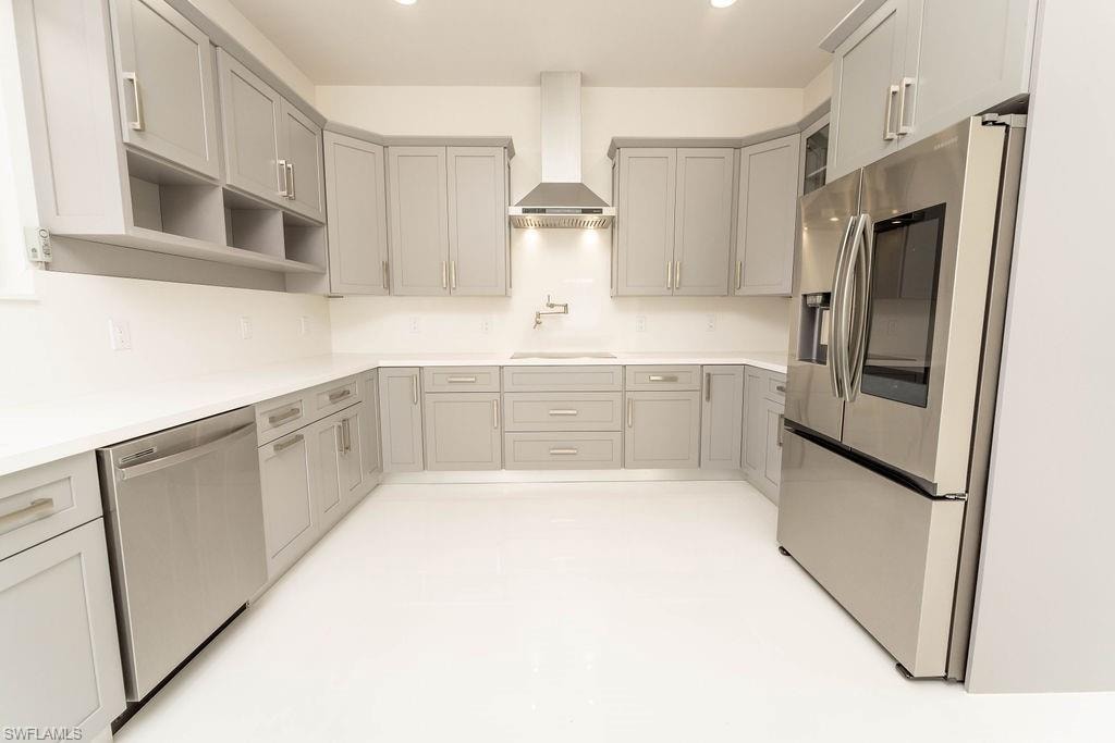 Kitchen with appliances with stainless steel finishes, gray cabinetry, wall chimney range hood, open shelves, and recessed lighting