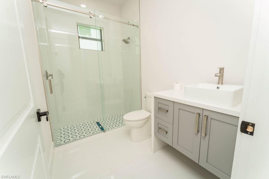 Full bathroom with vanity, a stall shower, and light tile patterned flooring
