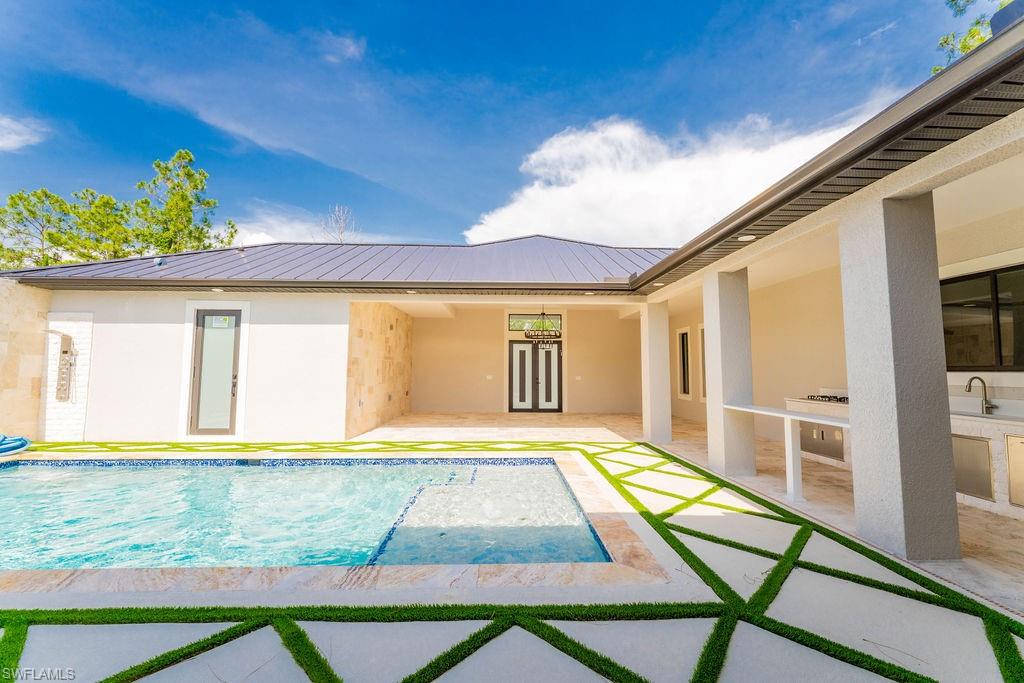 Outdoor pool featuring a patio and exterior kitchen