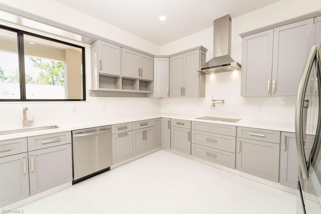 Kitchen with wall chimney range hood, appliances with stainless steel finishes, gray cabinetry, recessed lighting, and open shelves
