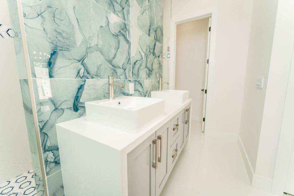 Full bath with double vanity and tile walls