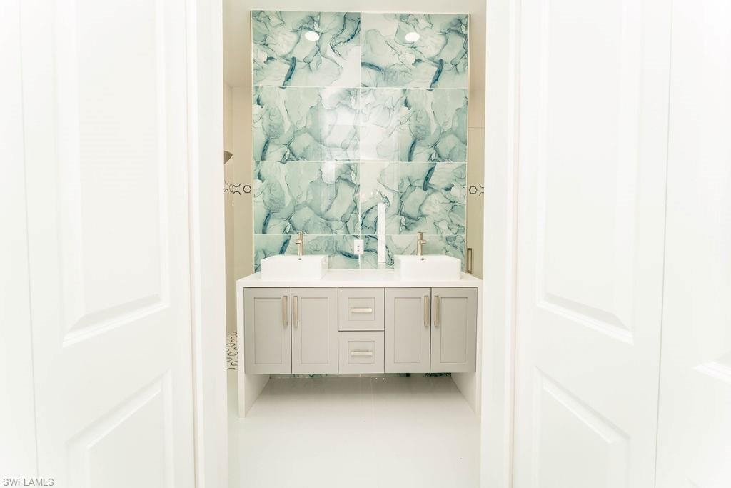 Bathroom featuring double vanity and tile walls