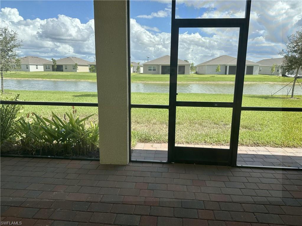 Unfurnished sunroom featuring a water view and a residential view