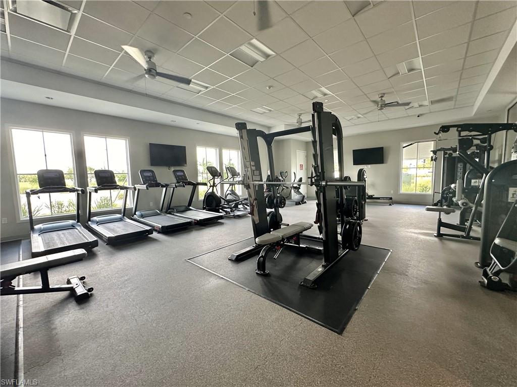 Gym featuring ceiling fan and a drop ceiling