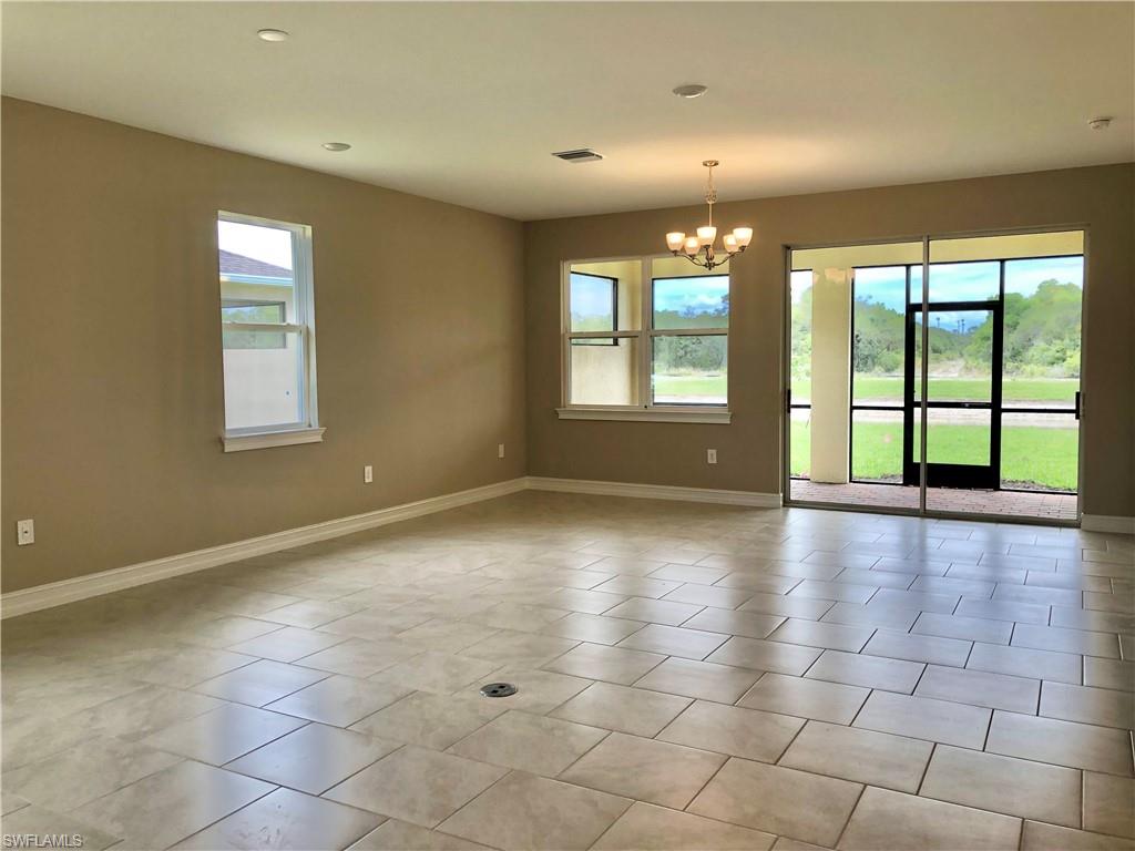 Empty room featuring a chandelier, light tile patterned floors, and recessed lighting