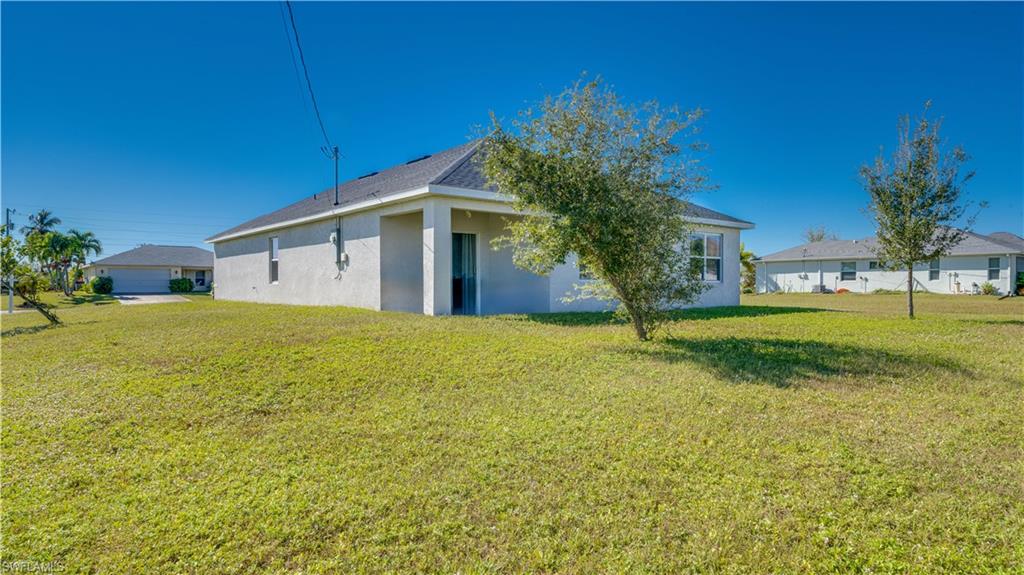 Rear view of house with a yard and stucco siding