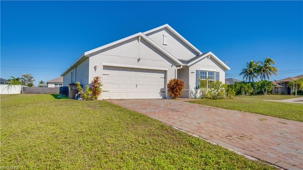 Ranch-style house with stucco siding, decorative driveway, and a garage