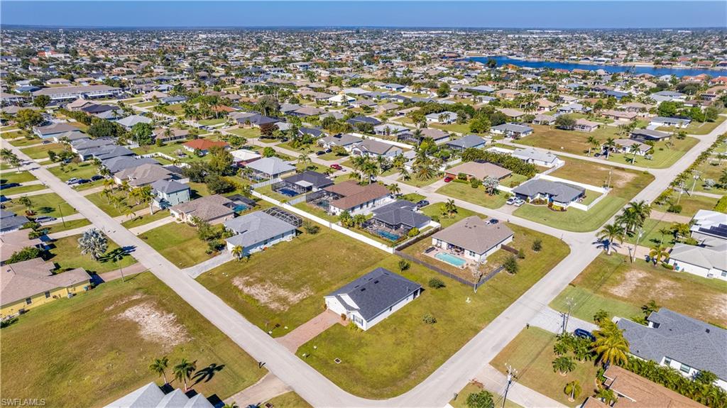 Aerial view of property and surrounding area with a large body of water and nearby suburban area