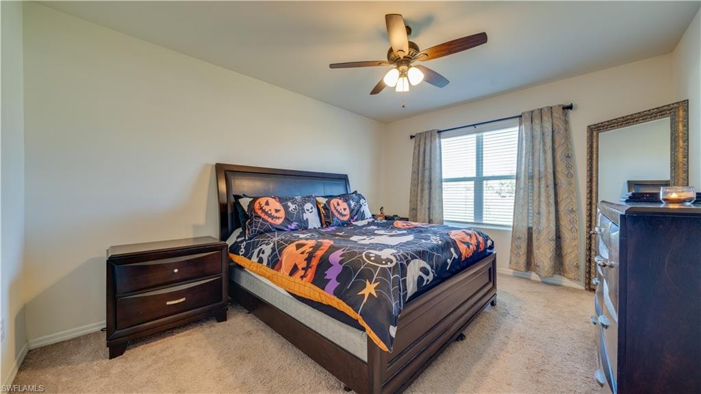 Bedroom featuring light colored carpet and a ceiling fan