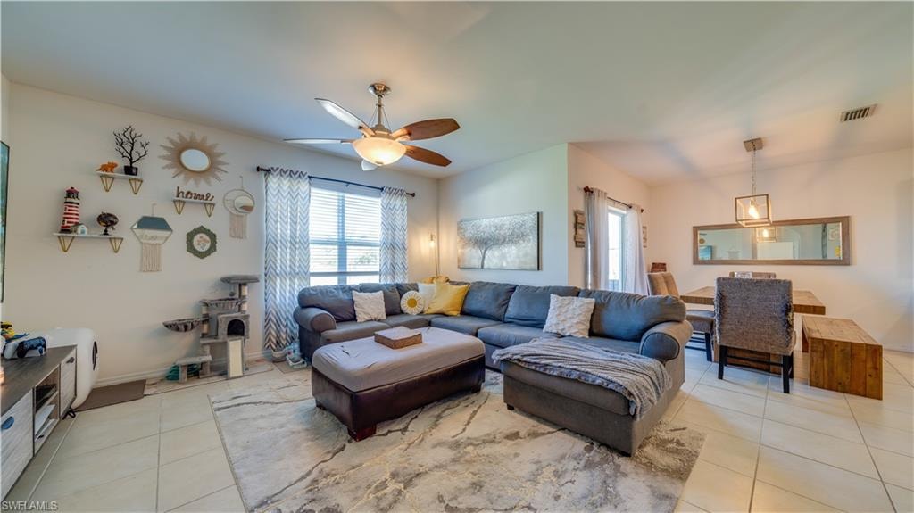 Living area with light tile patterned floors and ceiling fan