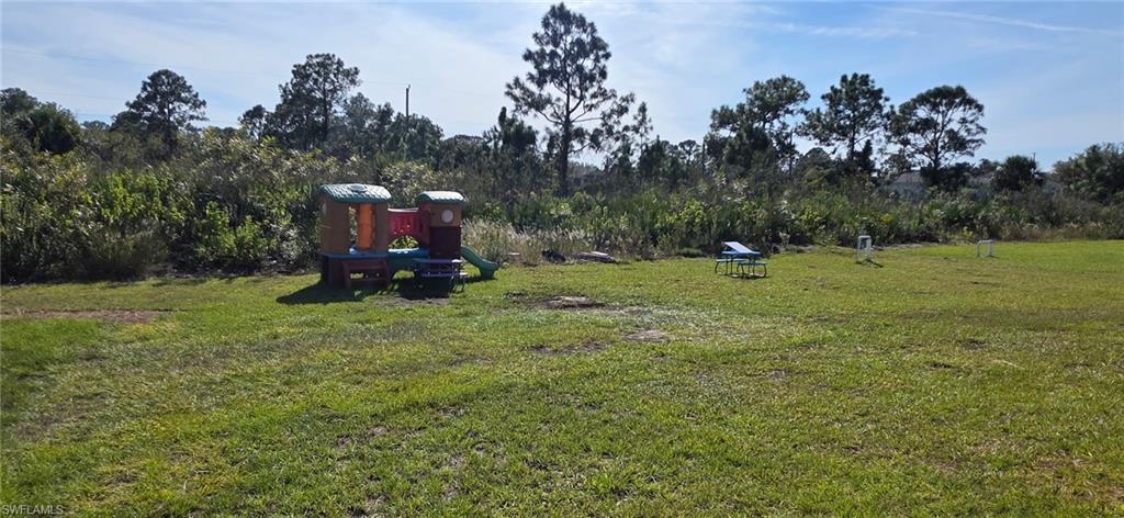 View of green lawn featuring a playground