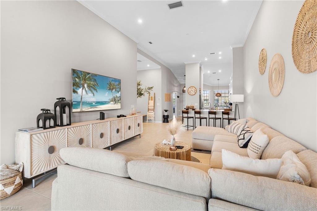 Living area with light tile patterned flooring, crown molding, and recessed lighting