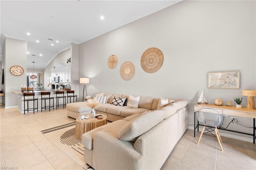 Living room featuring recessed lighting, light tile patterned floors, and crown molding