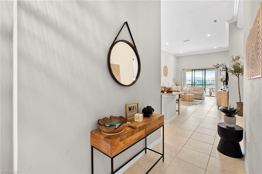 Hall with light tile patterned flooring and recessed lighting