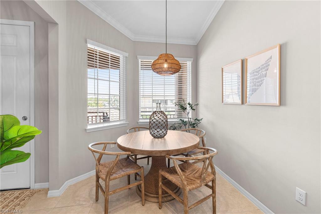 Dining area featuring crown molding and light tile patterned floors
