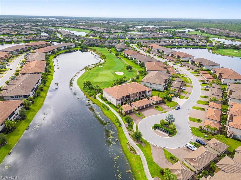 Aerial perspective of suburban area with a large body of water and a golf course
