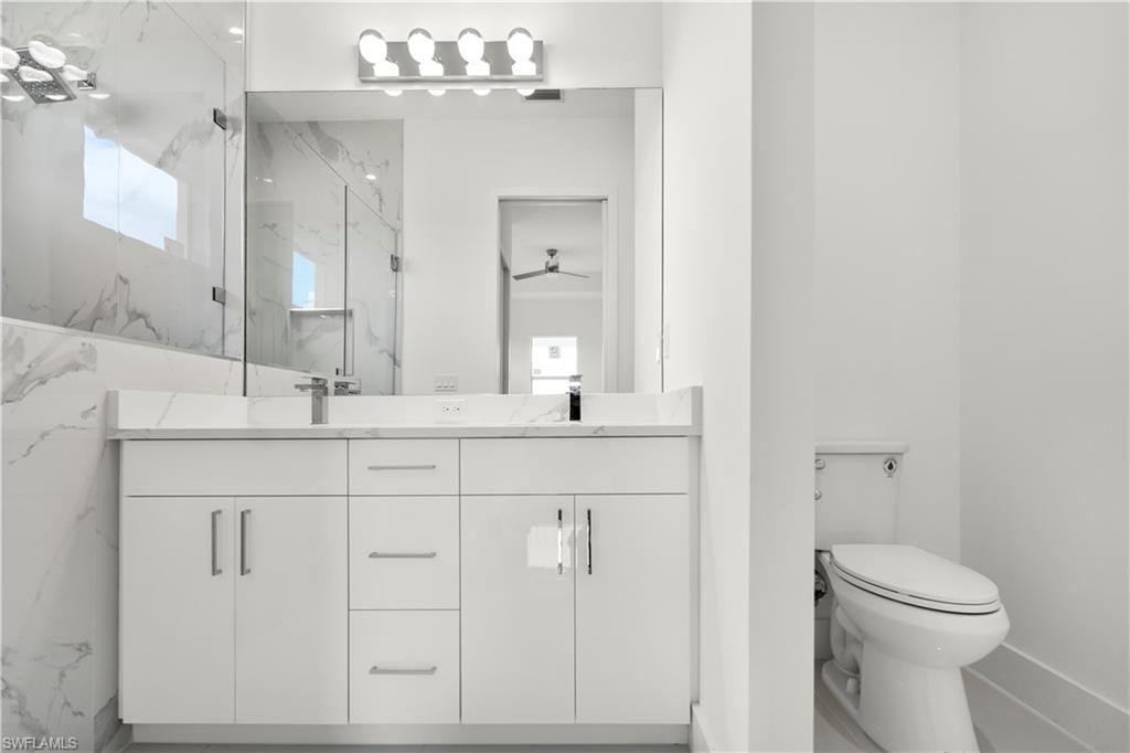 Full bathroom with a marble finish shower and double vanity
