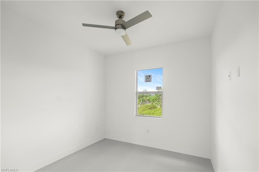 Unfurnished room with a ceiling fan and concrete floors