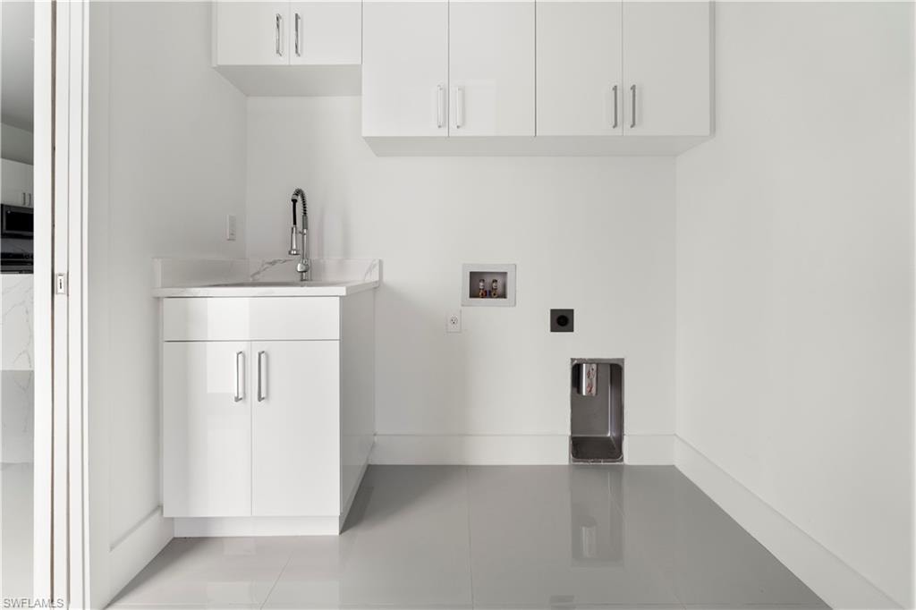 Laundry area featuring hookup for a washing machine, electric dryer hookup, and cabinet space