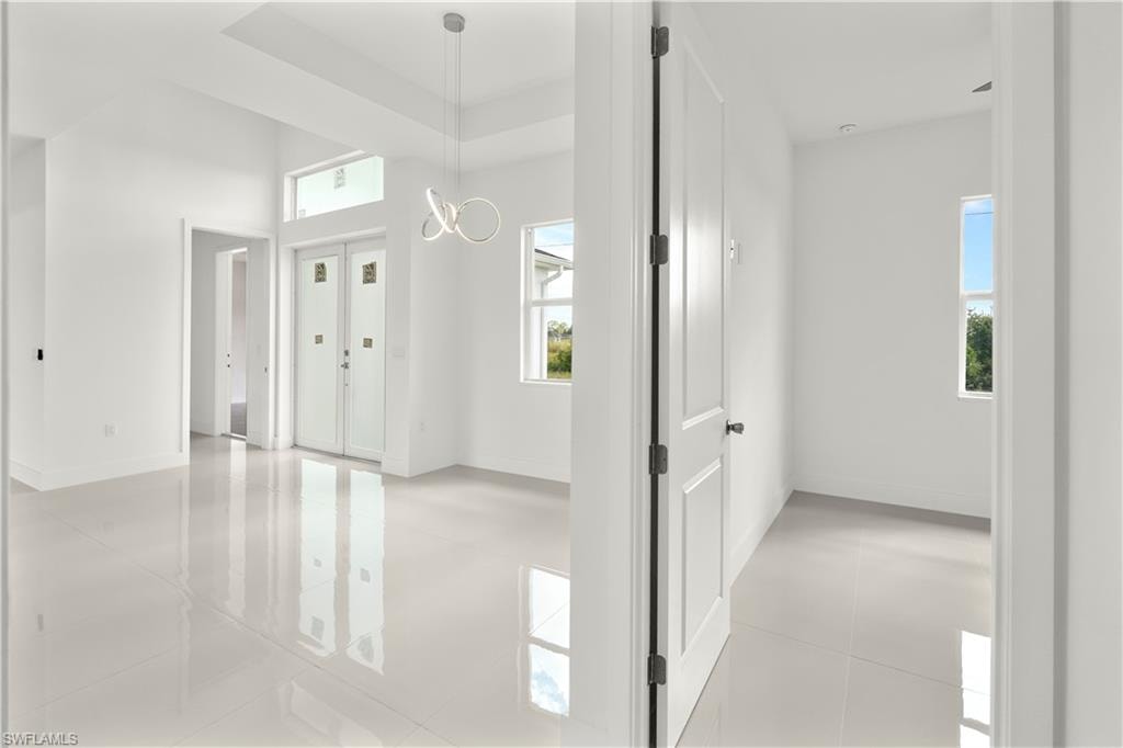 Entryway featuring a raised ceiling and a chandelier
