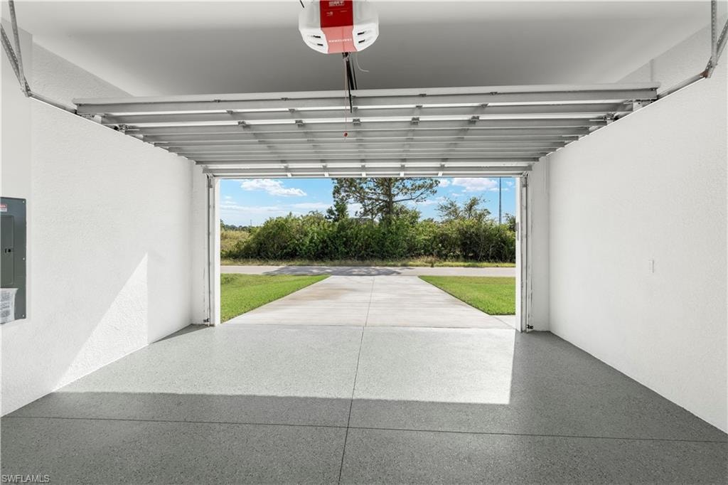 Garage featuring a garage door opener and electric panel