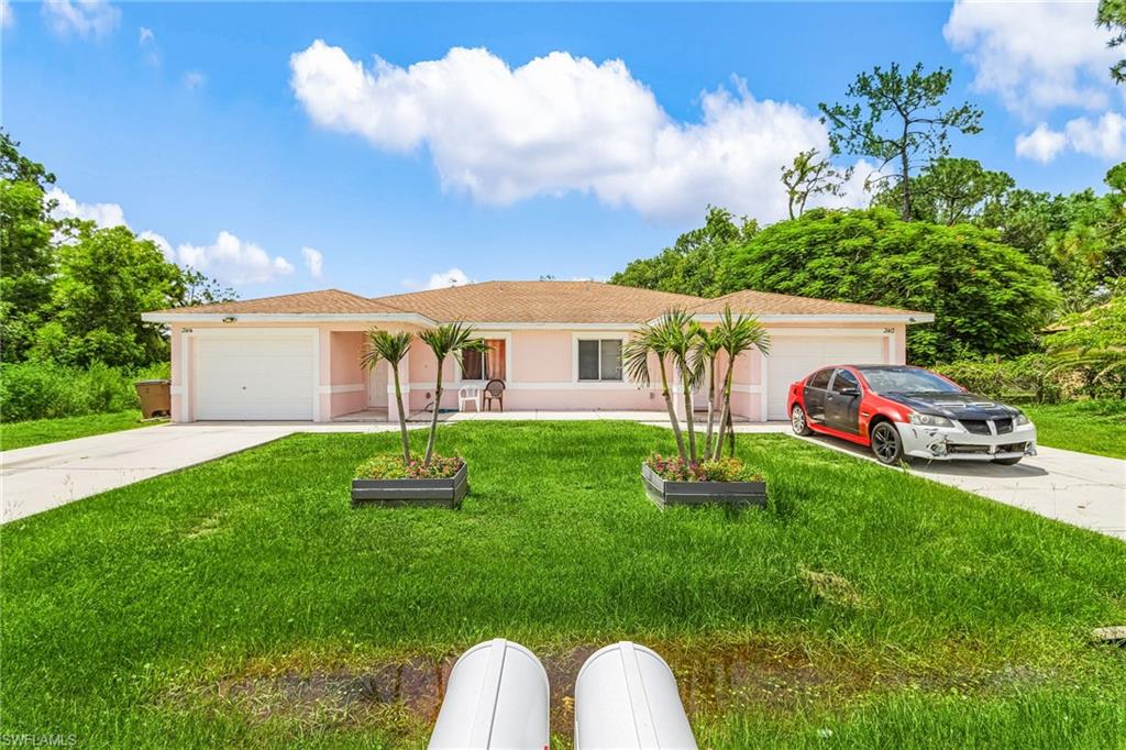 Single story home with concrete driveway, a front yard, a garage, and stucco siding