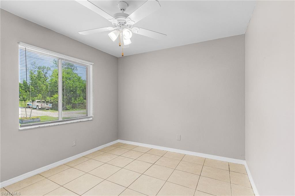 Empty room featuring light tile patterned floors and a ceiling fan
