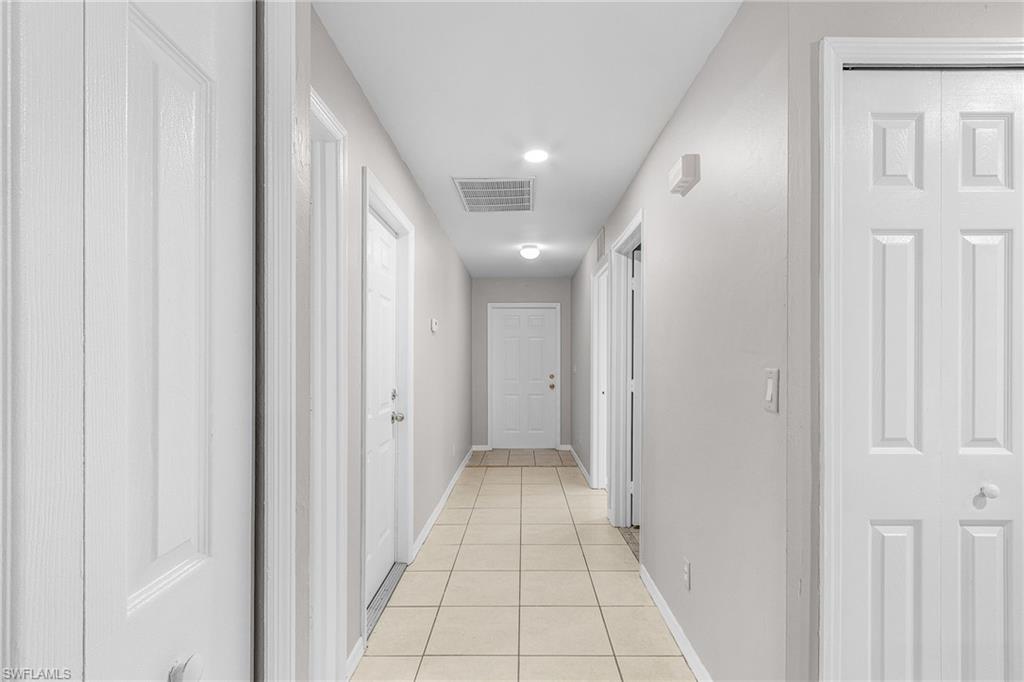 Hallway with light tile patterned flooring and recessed lighting