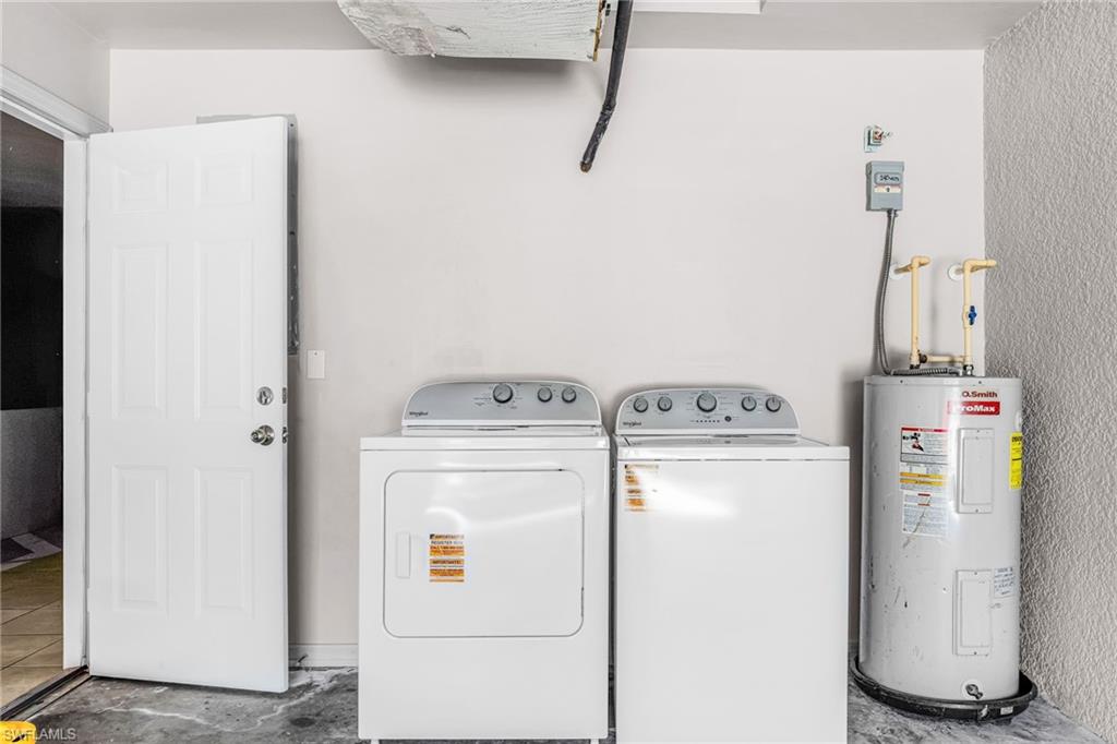 Washroom featuring electric water heater and independent washer and dryer