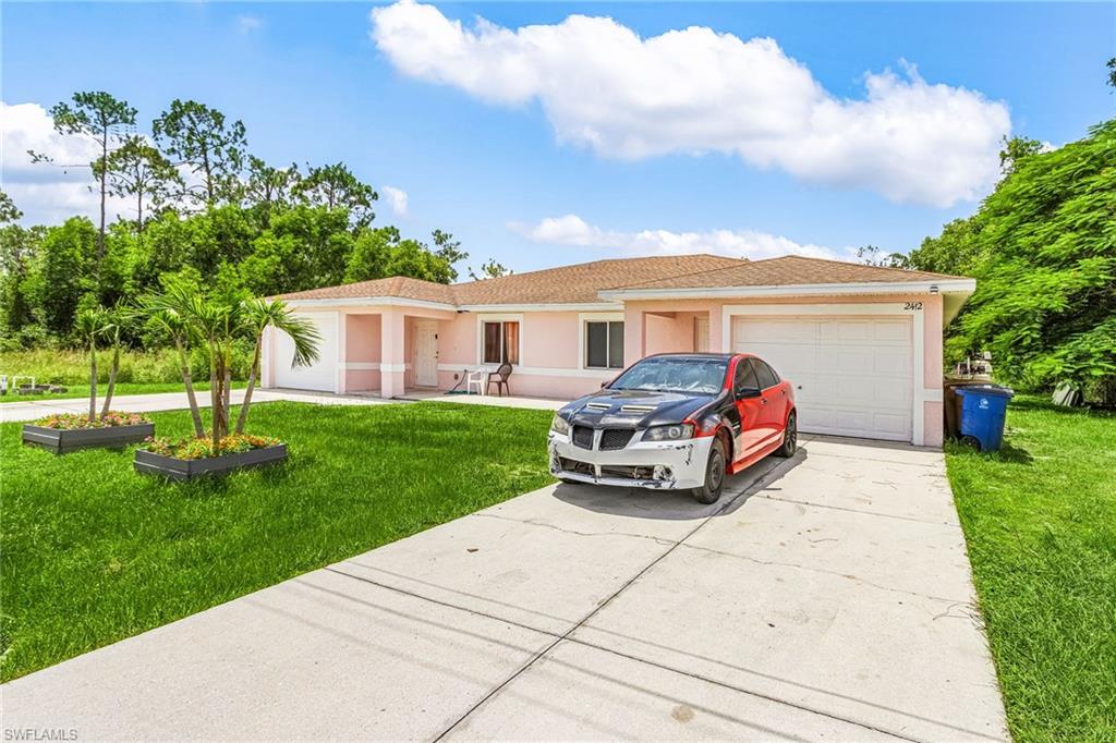 Ranch-style house with a front lawn, a garage, concrete driveway, and stucco siding
