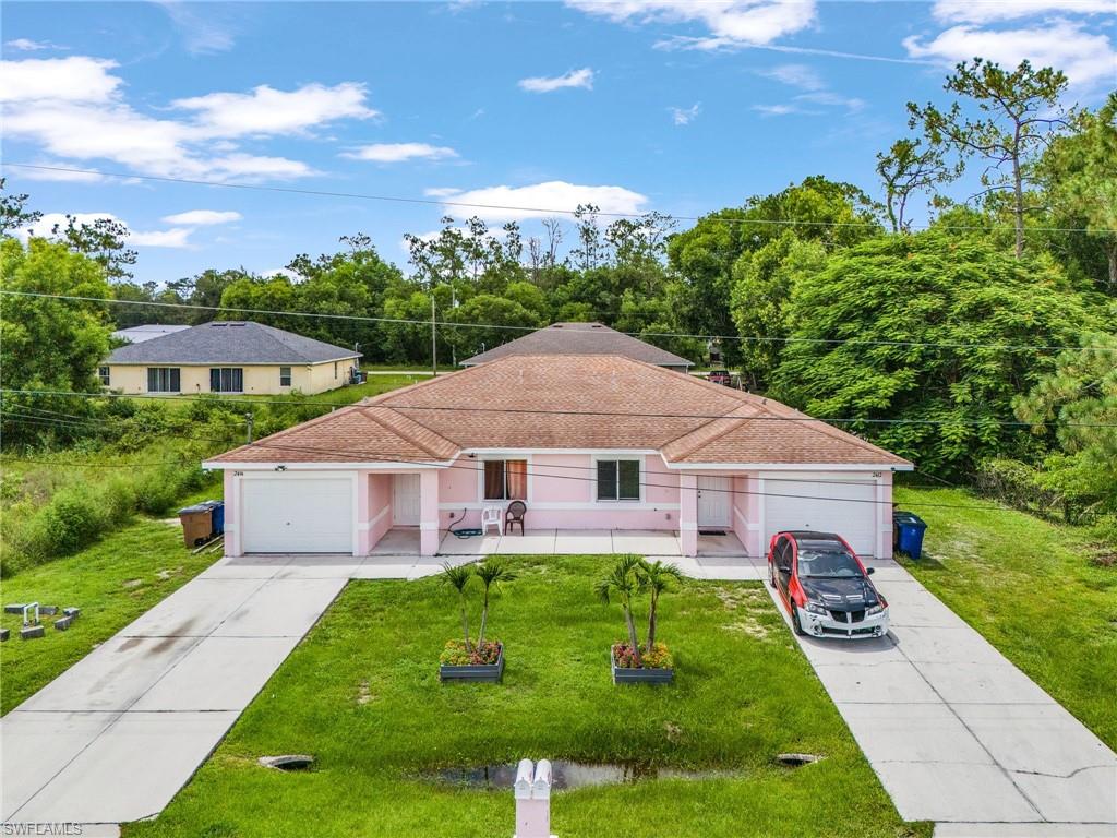 Ranch-style house with a front lawn, a shingled roof, a garage, and driveway