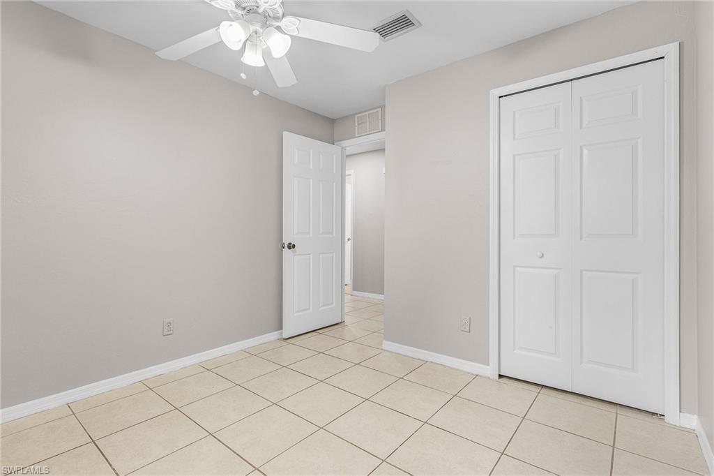 Unfurnished bedroom with light tile patterned floors, a ceiling fan, and a closet