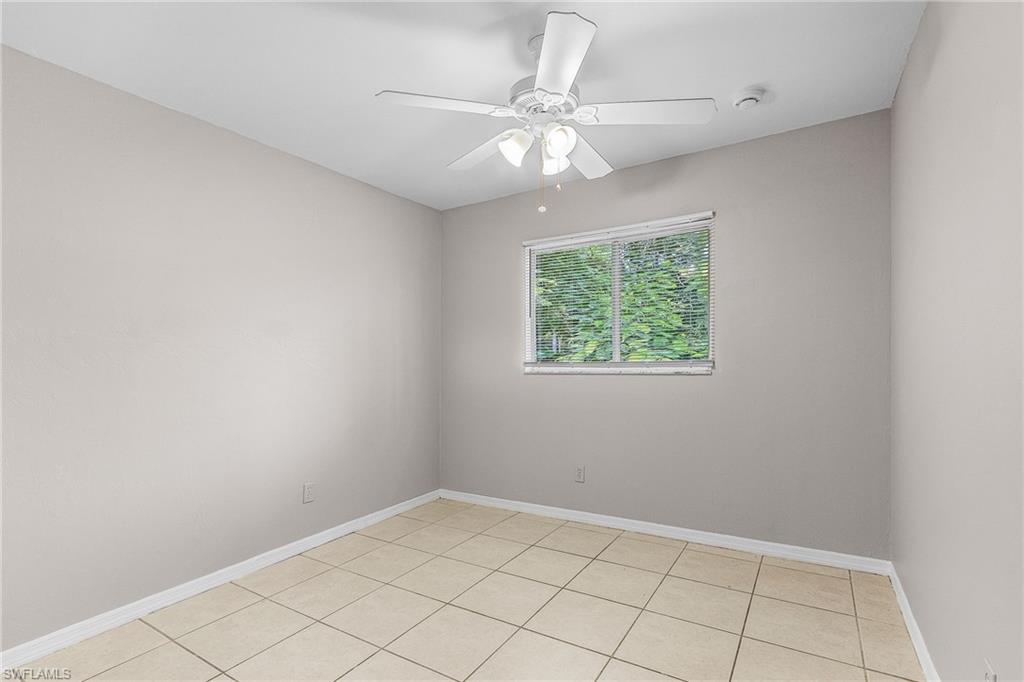 Unfurnished room featuring light tile patterned flooring and a ceiling fan
