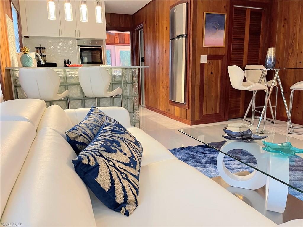 Living room with light tile patterned floors and wooden walls