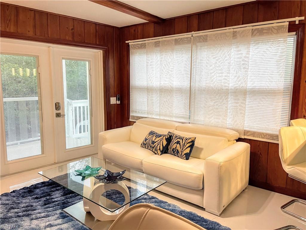 Living room with wood walls and beam ceiling