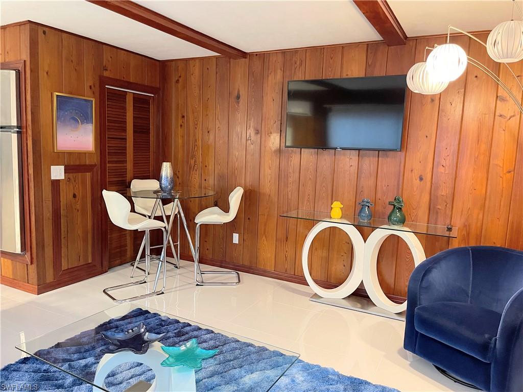 Workout room featuring beam ceiling, wood walls, and tile patterned flooring