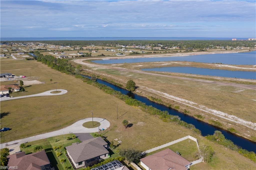 Aerial perspective of suburban area featuring a nearby body of water