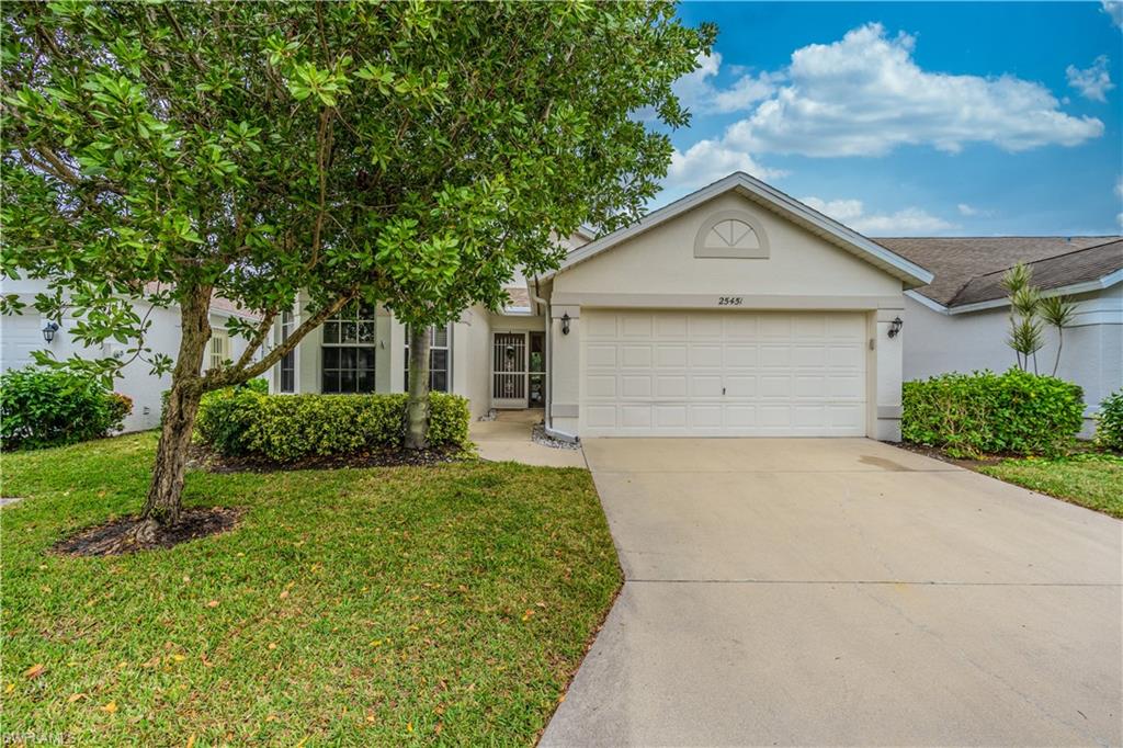 Ranch-style house featuring stucco siding, concrete driveway, a front lawn, and an attached two car garage