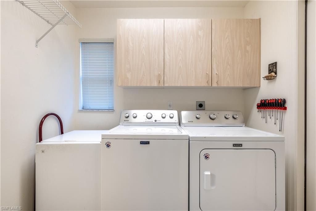 Laundry room with separate washer and dryer and cabinet space