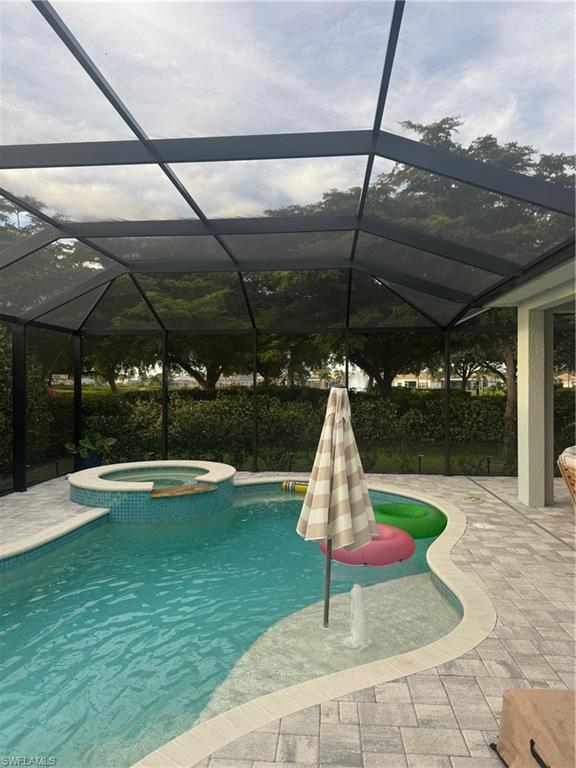 View of pool featuring a sundeck, a pool with connected hot tub,