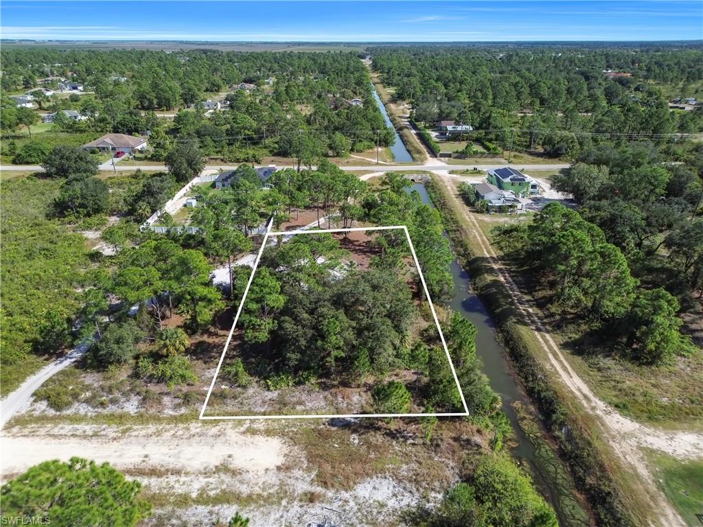 Aerial view of property's location featuring a forest and property parcel outlined