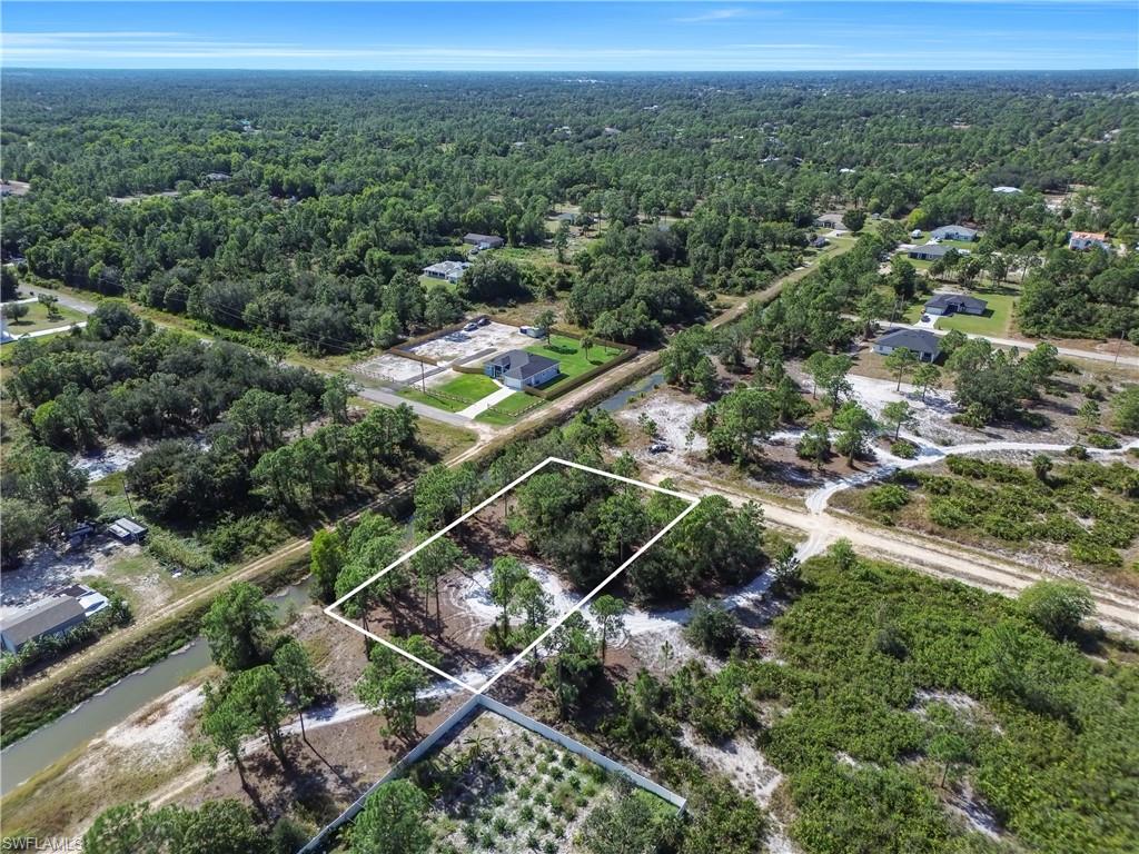 Aerial view of property's location featuring property parcel outlined and a forest