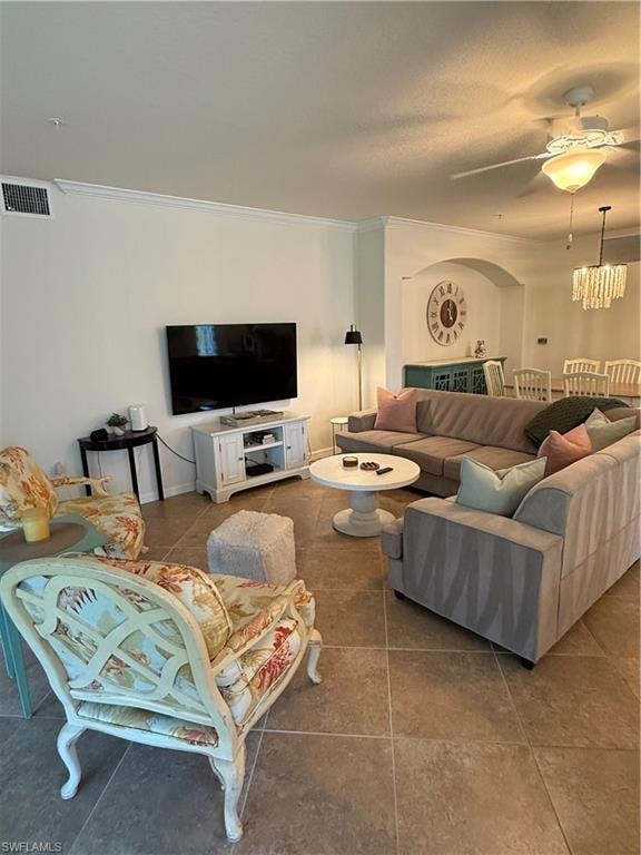 Living room featuring crown molding, ceiling fan, tile patterned flooring, and a textured ceiling